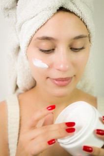 Hydration. Cream smear. Beuaty close up portrait of young woman with a healthy glowing skin is