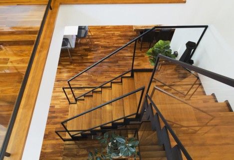 Top view of black powder coated steel L-shaped staircase with stained and varnished wooden steps
