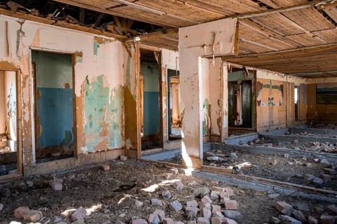 Destroyed abandoned classroom of the old school, wall painting with Soviet miners, ghost town,