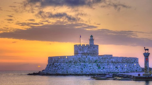 The fortress near the coast under a sky with sunset colours, sunrise, dawn, lighthouse, European