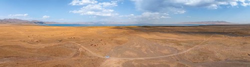 Road and off-road vehicle, Aerial view, Vast empty landscape at the mountain lake Song Kul in