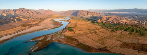 Naryn River between mountains and fields, at Toktogul Reservoir at sunset, aerial view, Kyrgyzstan,
