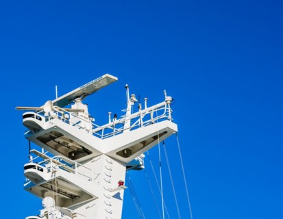 Radar assembly on mast of a coast guard frigate with the word Kelvin Hughes printed on the radar in