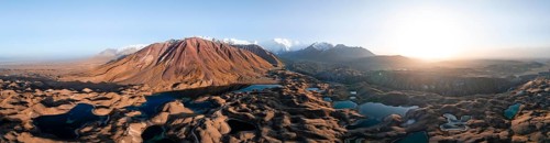 Atmospheric aerial view, high mountain landscape with glacier moraines and mountain lakes, behind