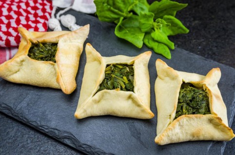 Delicious Lebanese (Arabic) food, spinach sfiha on black slate stone background and traditional