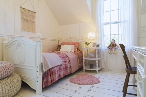 Single bed with red, pink and grey tartan bedspread, white painted antique style wooden headboard