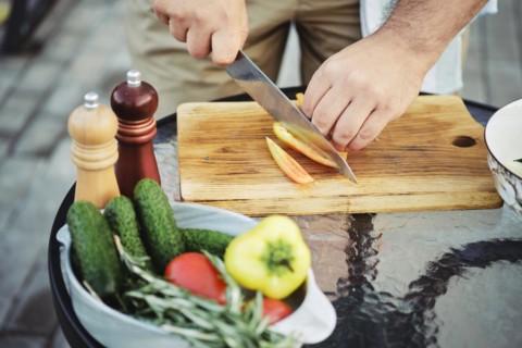 Unrecognizable man slicing sweet bell pepper for vegetable salad