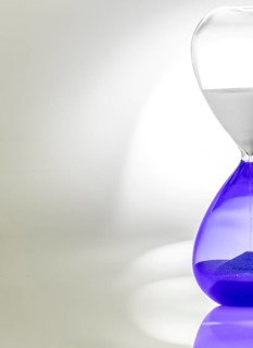 Hourglass with blue sand halfway through, minimalist design with shadows and reflections
