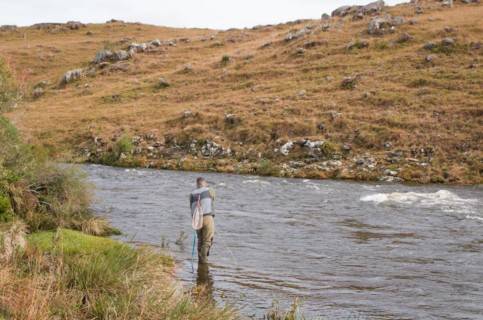 Fisherman fly fishing rainbow trout on mountain in beautiful scenery