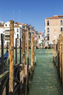 Mooring poles and gondola on Grand Canal with Renaissance architectural style residential palace