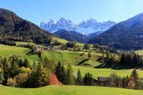 Autumn mountain landscape with a village surrounded by colourful trees, Italy, Trentino-Alto Adige,