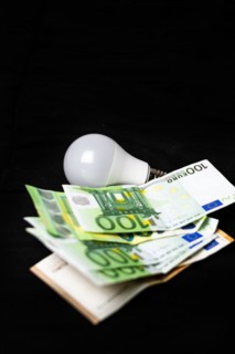 Electric light bulb on money and coins Finance and saving electricity. Concept of saving light and