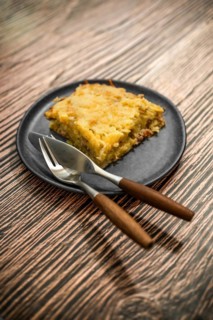 Plate with meat and grated potato pie on ceramic plate on rustic table