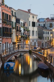Moored boats and footbridge over Rio de la Toletta Canal with old architectural style residential