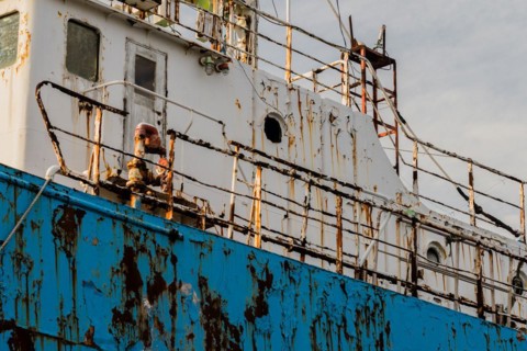 Closeup of side old rusty abandoned ship taken at a marine junkyard in South Korea