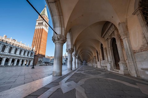 Colonnade of the Doge's Palace with Campanile bell tower in Piazetta San Marco, St Mark's Square,