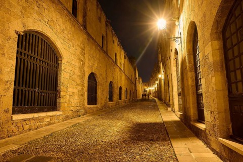 An old cobbled street at night, illuminated by street lamps creating a warm atmosphere, Knights
