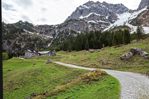 Hiking trail through green meadows, behind Hintere Gemstel-Huette and Widderstein, Gemsteltal,