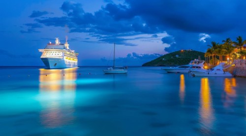 A large cruise ship docked near popular vacation resort. The scene is serene and relaxing, with the