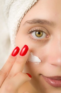 Hydration. Cream smear. Beuaty close up portrait of young woman with a healthy glowing skin is