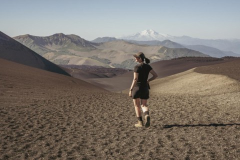 Young woman walking through lava fields, Crater Navidad, Lonquimay volcano, Malalcahuello National