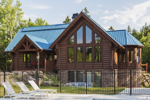 Brown stained milled Eastern white pine timber and flat log profile home facade with stone cladding