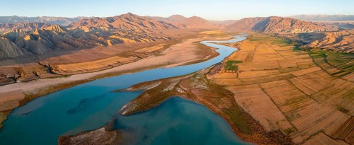 Naryn River between mountains and fields, at Toktogul Reservoir at sunset, aerial view, Kyrgyzstan,