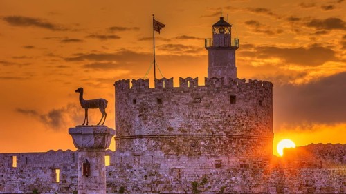 An old castle with a statue in honour of a sunrise under bright clouds, Sunrise, Dawn, Fort of