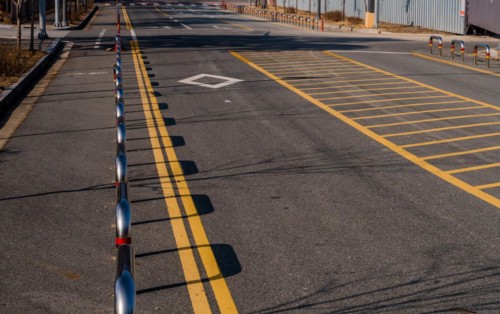 Chrome metal traffic barriers separating bicycle lane from automobile lane on urban street in South