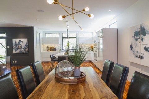 Rosewood dining table with dark brown leather high back chairs in dining room with acacia wood