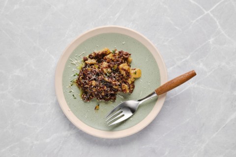 Plate with risotto with pink rice, pear and blue cheese on a table