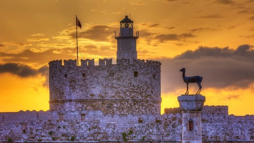 The ancient structure of a castle with a lighthouse during a picturesque sunrise, sunrise, dawn,