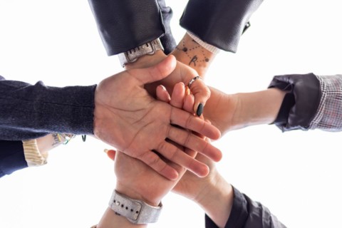Low angle of group of people bumping fists. Togetherness and togetherness concept