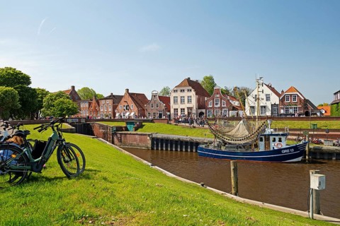 Picturesque cutter harbour, Greetsiel, ebikes, gabled houses, Krummhoern, East Frisia, Germany,