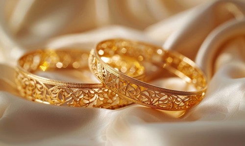 Pair of intricately designed gold bracelets arranged on a smooth satin material background AI