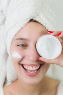 Skincare, product and woman with cream on face, and excited advertising luxury skin care promotion.