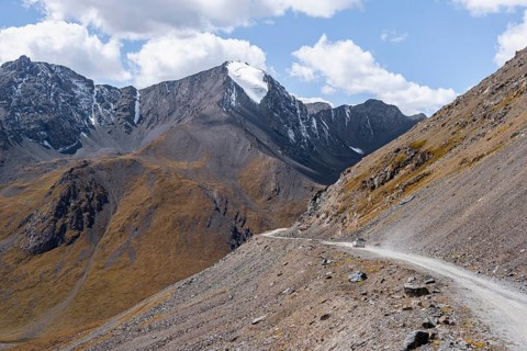 Off-road car on mountain pass, gravel road in the mountains in Tien Shan, Engilchek Valley,