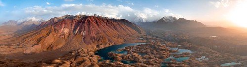 Atmospheric aerial view, high mountain landscape with glacier moraines and mountain lakes, behind