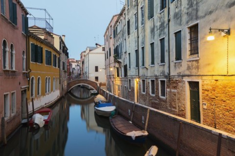 Moored boats and footbridge over Rio de la Toletta Canal with old architectural style residential