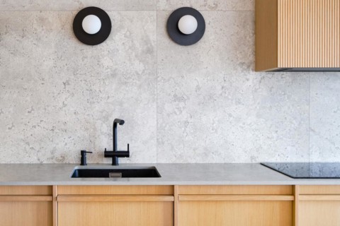 Contemporary, minimalist kitchen interior featuring a sleek black sink and faucet set against a