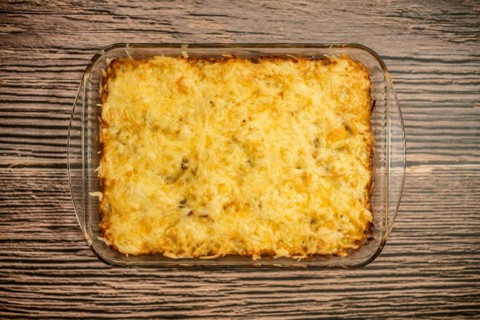 Top view of pie with meat and potato baked in oven in glass baking tray