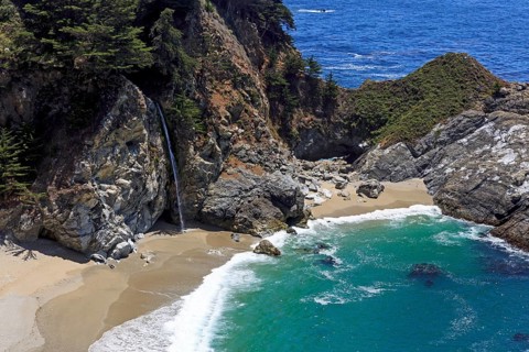 A powerful waterfall flows between rocky cliffs into the sea, Big Sur Pfeiffer, US 1, North