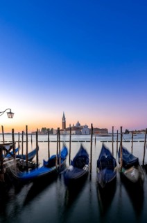 Venetian gondolas, boat dock at St Mark's Square, church of San Giorgio Maggiore in the background,