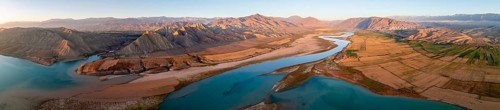 Panorama, Naryn river between mountains and fields, at Toktogul reservoir at sunset, aerial view,