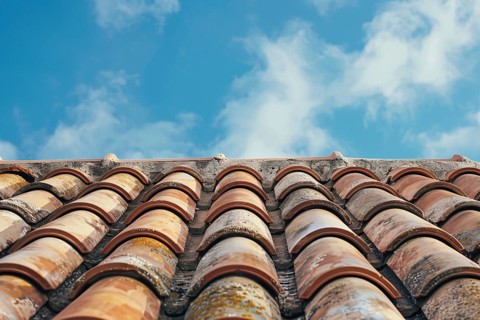 Close up of roof with red ceramic tiles and blue sky. KI generiert, generiert, AI generated