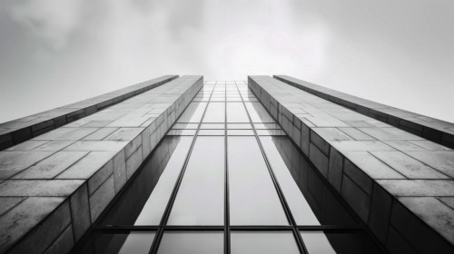 Symmetrical greyscale image viewed from below a modern building, showcasing its geometric design,
