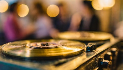 A vinyl record on a turntable with a golden bokeh effect in the foreground, AI generated