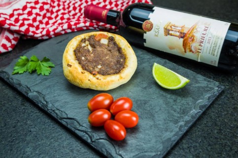 Delicious Lebanese (Arabic) food, legitimate sfihas on a black granite background with tomatoes,