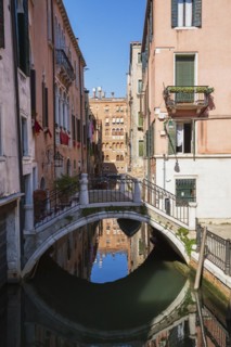 San Angelo Canal with footbridge and old pinkish and white architectural style residential
