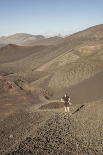 Young woman walking through lava fields, Crater Navidad, Lonquimay volcano, Malalcahuello National